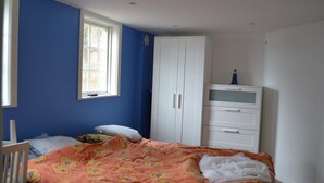A bedroom with a bed, a wardrobe, a window, and a crib. - 4 Star Holiday Home in Musko (Muskö)