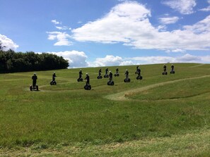 A group of people on segways in a grassy field with a clear sky. - 4 Person Holiday Home in Rudkobing (Rudkobing)
