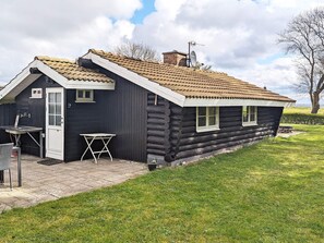 A log cabin with a pitched roof, a small porch, and a satellite dish. - 4 Person Holiday Home in Rudkobing (Rudkobing)