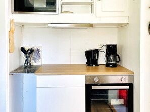 A kitchen with a wooden countertop, a coffee maker, a toaster, and a built-in oven. - 4 Person Holiday Home in Dals Rostock (Dals Rostock)