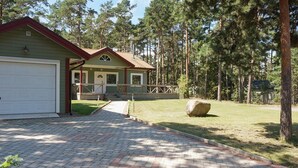 A two-story house with a garage, a covered porch, and a stone pathway leading to the entrance. - 4 Star Holiday Home in Monsteras (Monsteras)