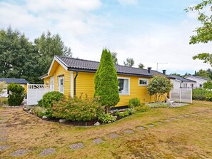 A yellow mobile home with a fenced yard, surrounded by greenery and trees. - 7 Person Holiday Home in Mellbystrand (Mellbystrand)