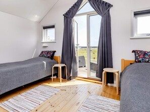 A bedroom with two beds, a window, and a view of the outdoors. - 6 Person Holiday Home in Hadsund (Hadsund)