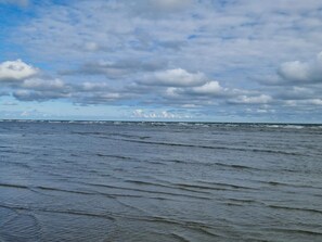 A beach with waves and a cloudy sky. - 6 Person Holiday Home in Hadsund (Hadsund)