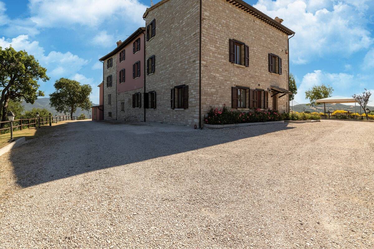 A stone building with a gravel driveway and a covered outdoor seating area.
