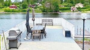 A dock with a barbecue grill, outdoor seating, and a lamp post. - 4 Star Holiday Home in Vaddo (Väddö)