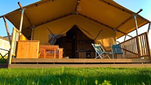A wooden cabin with a large canopy, a wooden deck, and two folding chairs. - Farmhouse Tent in Fermo Near Adriatic Sea (Fermo)