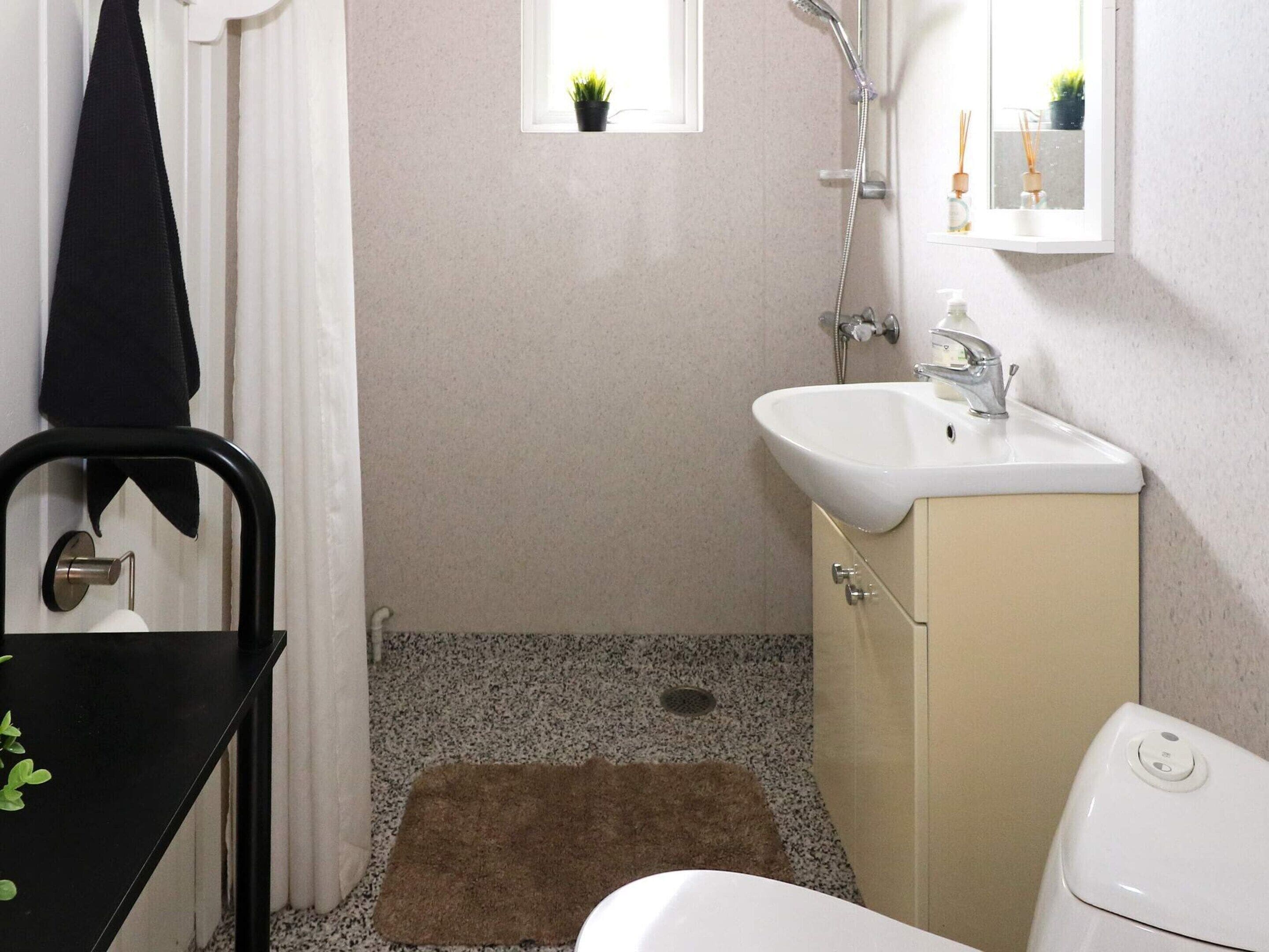 A bathroom with a sink, mirror, and toilet.