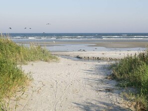 A sandy beach path leading to the ocean with waves crashing onto the shore. - 6 Person Holiday Home in Hadsund (Hadsund)