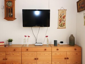 A flat-screen TV mounted on a wall above a wooden cabinet with drawers. - 6 Person Holiday Home in Hadsund (Hadsund)