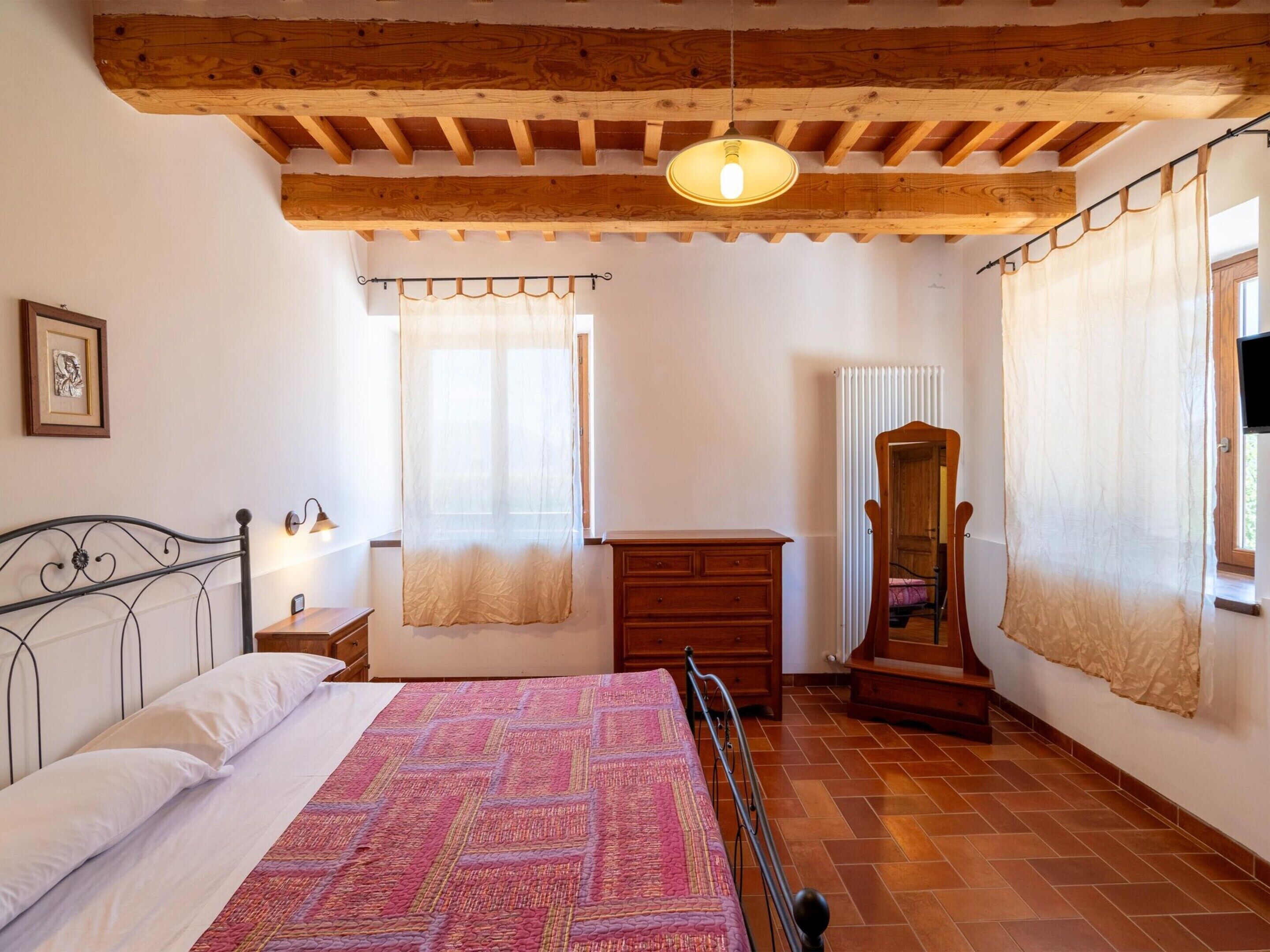 Une chambre à coucher avec un lit, une commode en bois et un miroir.