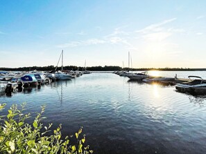 En lysthavn med fortøjede både, stille vand og en klar himmel.