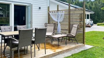 An outdoor patio with wicker furniture and a pergola.