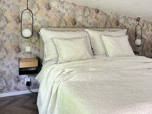 A bedroom with a bed, bedside tables, and wall-mounted lamps. - 4 Star Holiday Home in Ljungby (Ljungby)