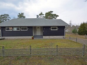 A single-story house with a dark exterior, a front door, and a small porch. - 7 Person Holiday Home in Mellbystrand (Mellbystrand)