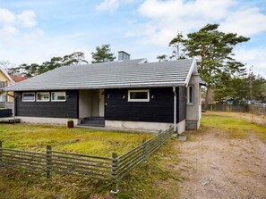 A modern two-story house with a dark exterior, a sloped roof, and a small porch. - 7 Person Holiday Home in Mellbystrand (Mellbystrand)