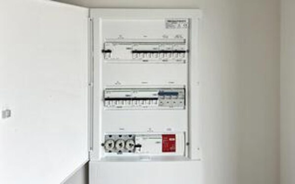 A white electrical panel with multiple switches and circuit breakers. - 5 Star Holiday Home in Romo (Rømø)