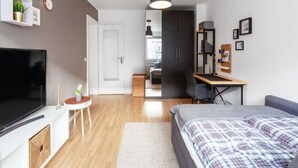 A modern, compact bedroom with a bed, a desk, and a TV. - Modern Apartment Fully and High Quality (Heilbronn)