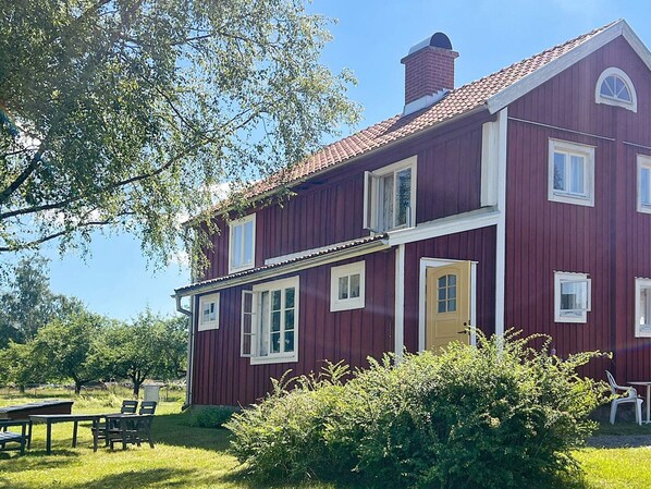 A two-story red building with multiple windows and a chimney.