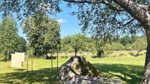 A park bench under a tree with a picnic table nearby. - 5 Star Holiday Home in Urshult (Urshult)