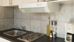 A kitchen with a stove, sink, and a coffee maker. - 4 Star Holiday Home in Karlskrona (Karlskrona)