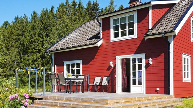 A red house with a porch, a table, and chairs. - 5 Person Holiday Home in Hedekas (Hedekas)