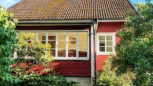 A red house with a tiled roof, large windows, and a chimney. - 5 Person Holiday Home in Hedekas (Hedekas)