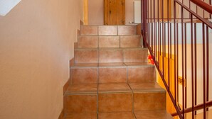 A staircase with brown tiles, a wooden door, and a heart-shaped decoration on the wall. - Mountain Apartment With Balcony for Families (Uderns)