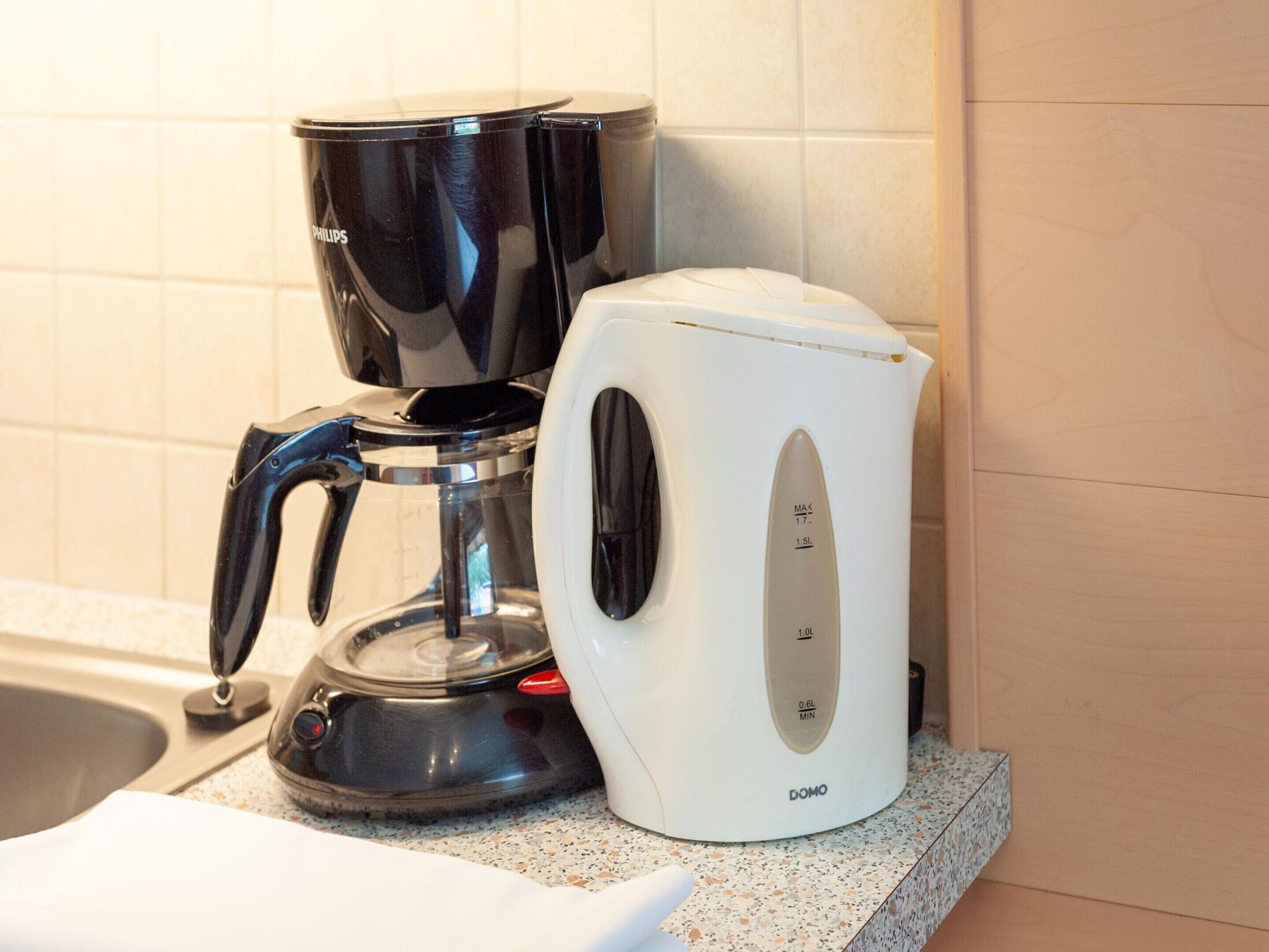 Une machine à café et une bouilloire sur un plan de travail de cuisine.