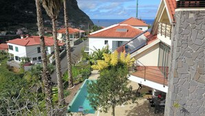 A residential area with houses, a swimming pool, and a view of the ocean.