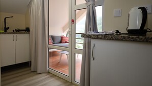 Una cocina con una puerta corrediza de vidrio que da a un espacio de estar exterior.