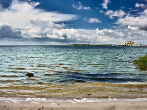 A coastal scene with a sandy beach and a body of water.
