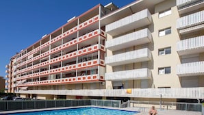 Un hôtel à plusieurs étages doté d’une piscine, d’un espace extérieur aménagé et de balcons.