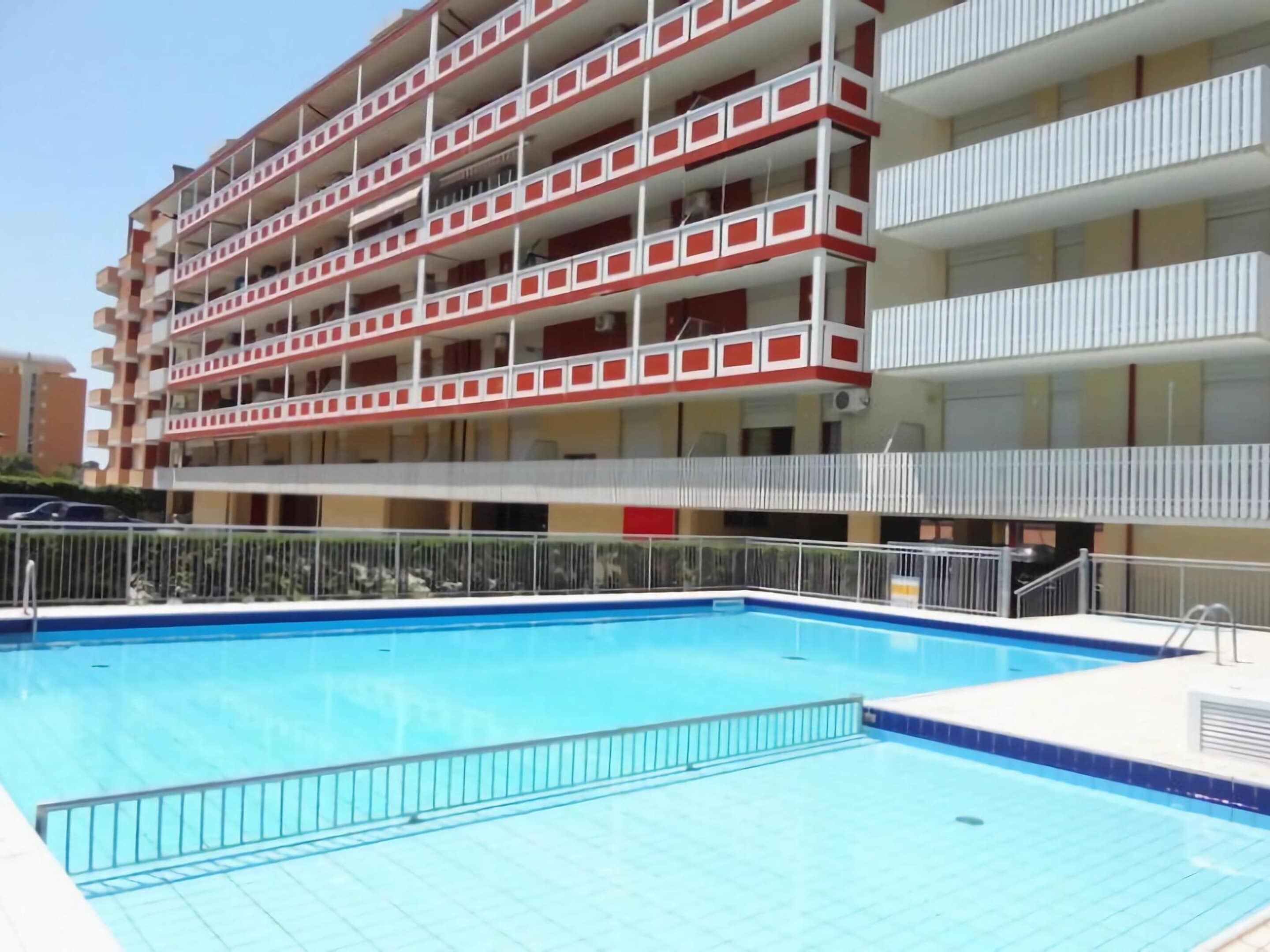 A multi-story hotel with a swimming pool.