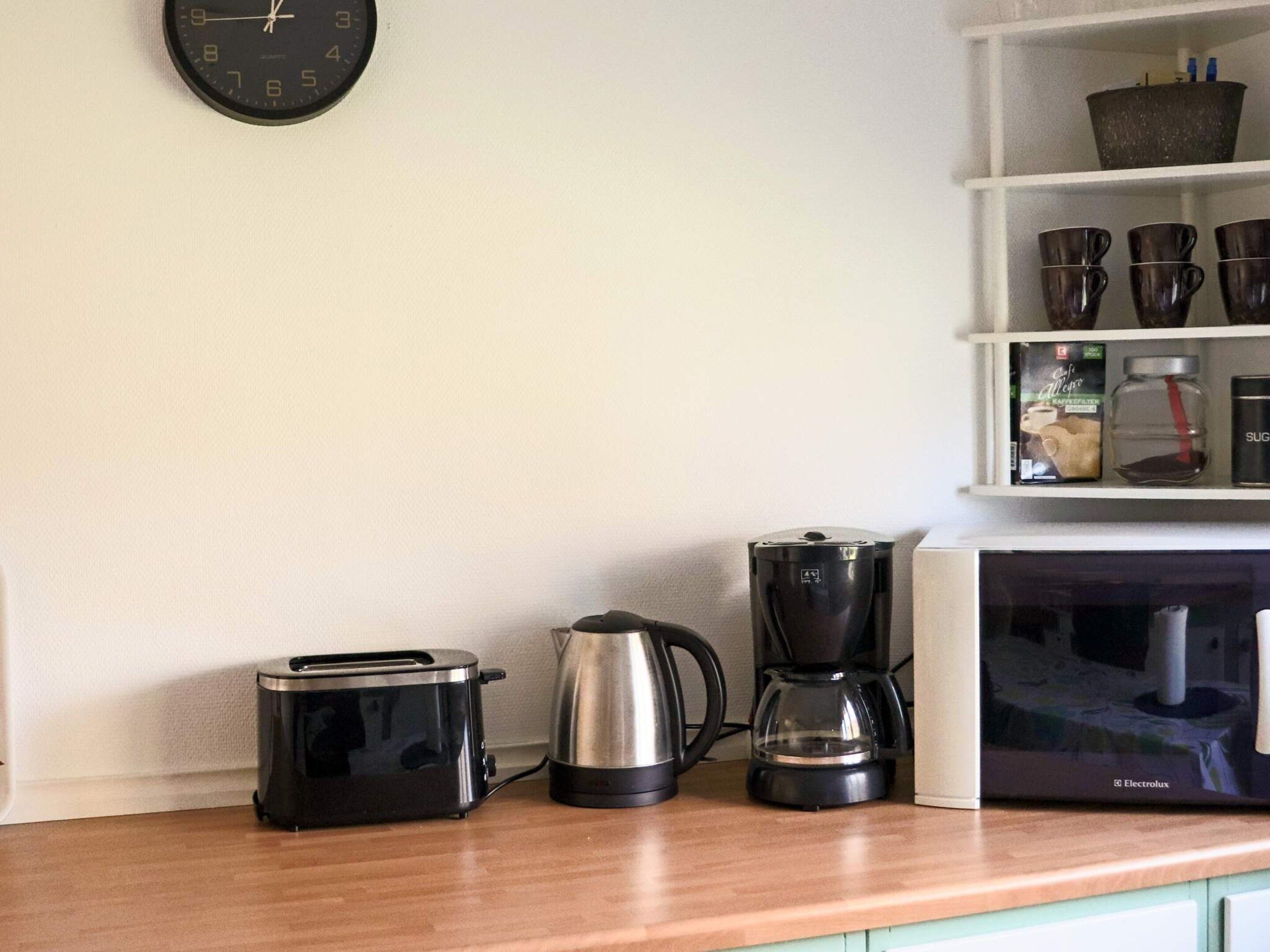 Eine Küchenarbeitsplatte mit einem Toaster, einer Kaffeemaschine und einer Mikrowelle.