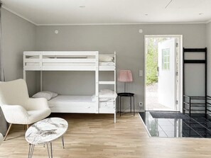 A bunk bed room with a chair and a small table. - 4 Star Holiday Home in Klintehamn (Klintehamn)