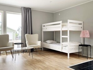 A room with a bunk bed, a chair, a small table, and a lamp. - 4 Star Holiday Home in Klintehamn (Klintehamn)