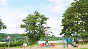 Un parque infantil con columpios, un tobogán y un arenero.
