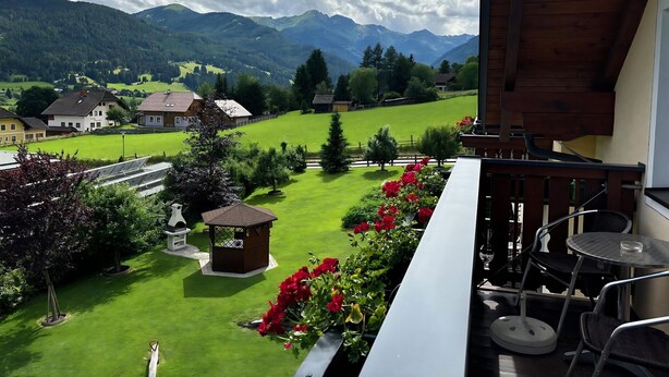 A balcony with a view of a green landscape, a wooden building, and a small gazebo. - Apartment in Lungau Near Ski Lift (Sankt Michael im Lungau)