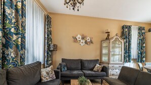 Un salon avec un canapé de couleur gris foncé, une table basse en bois et un meuble avec des portes en verre.