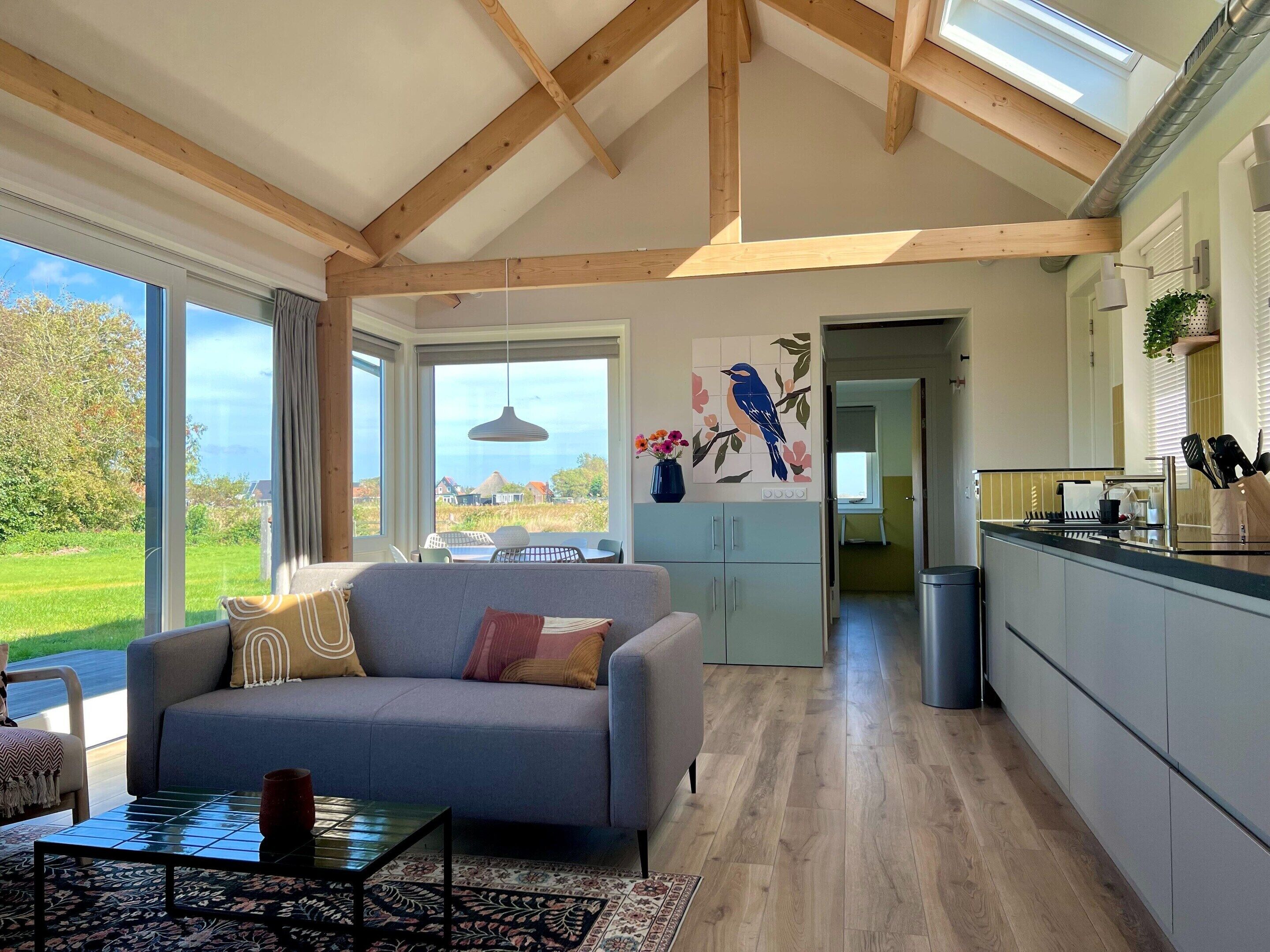 A spacious living area with a grey sofa, a coffee table, and a view of the outdoors.