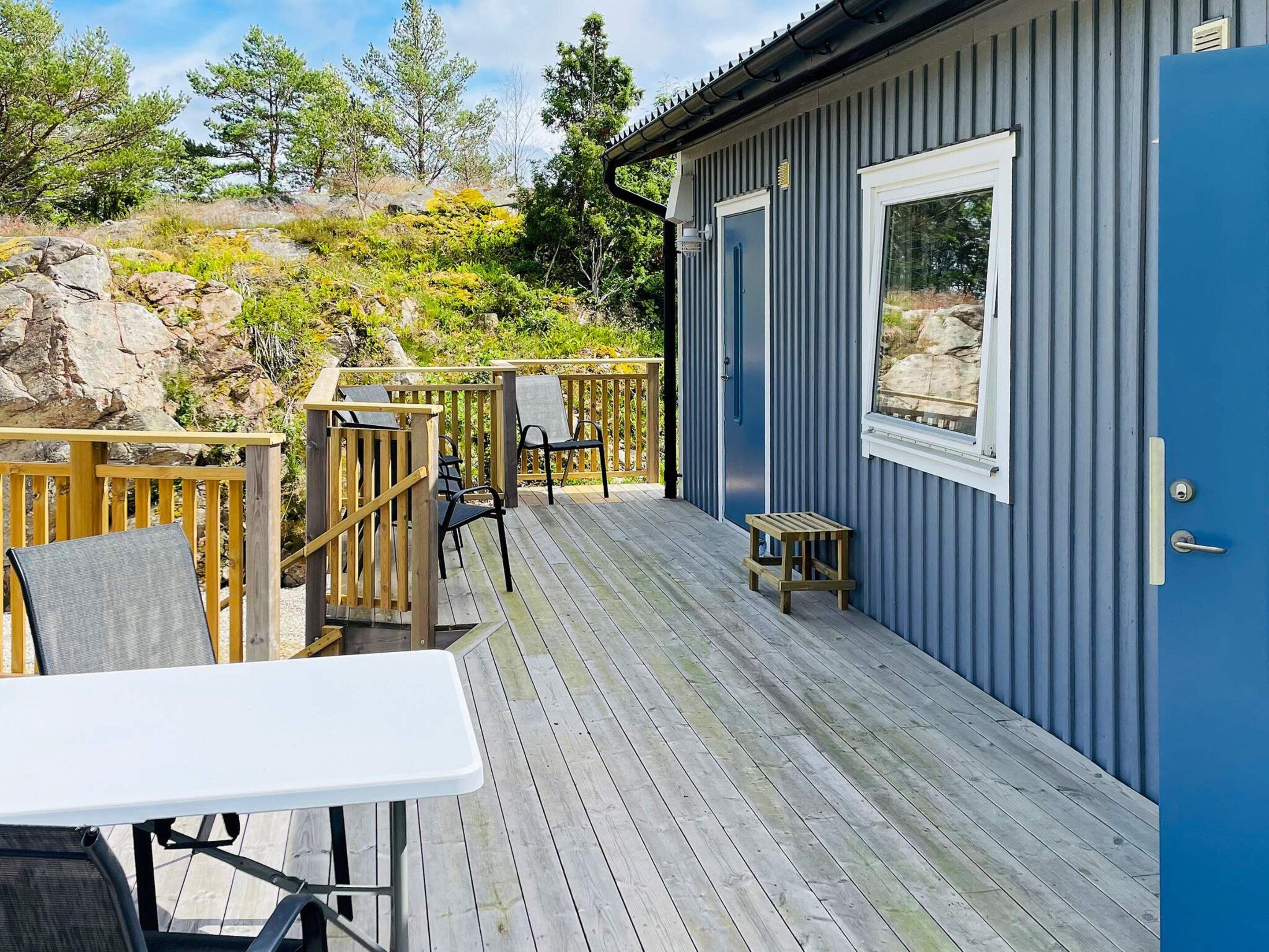 Una terrazza con mobili da esterno, un tavolino e una porta che dà su un edificio.