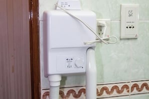 A white portable air purifier with a control panel and a power cord plugged into a wall socket. - Long Shao Heng Hotel (Beijing)