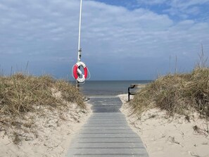 A beach path with a lifebuoy, a bench, and a clear sky. - 4 Star Holiday Home in Farhult (Hoganas)