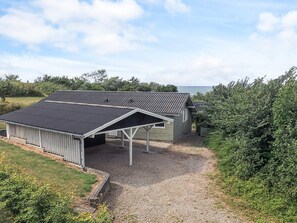 A two-story building with a covered outdoor area and a view of the sea. - 6 Person Holiday Home in Brenderup Fyn (Middelfart)