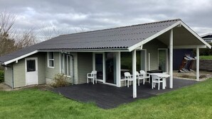 Una casa a un piano con portico coperto, una porta e una finestra.