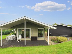 A covered patio with a table and chairs, a grill, and a wooden deck. - 6 Person Holiday Home in Brenderup Fyn (Middelfart)
