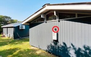 A single-story building with a grey exterior, a small attached structure, and a no-entry sign. - 7 Person Holiday Home in Vestervig (Vestervig)