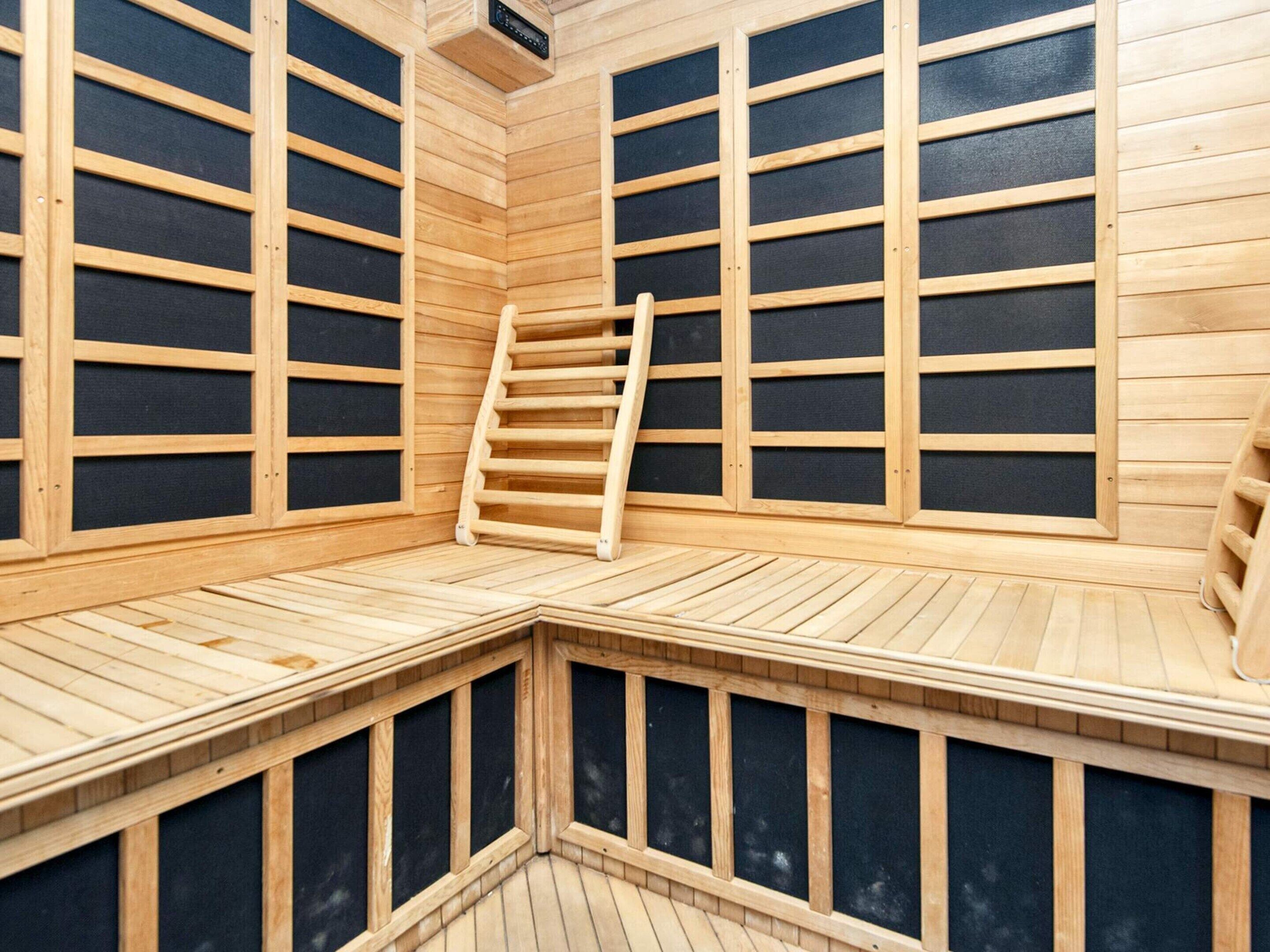 Un sauna con bancos de madera y una escalera.