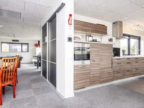 A modern kitchen with a built-in oven, microwave, and a large window. - 5 Star Holiday Home in Glesborg (Glesborg)